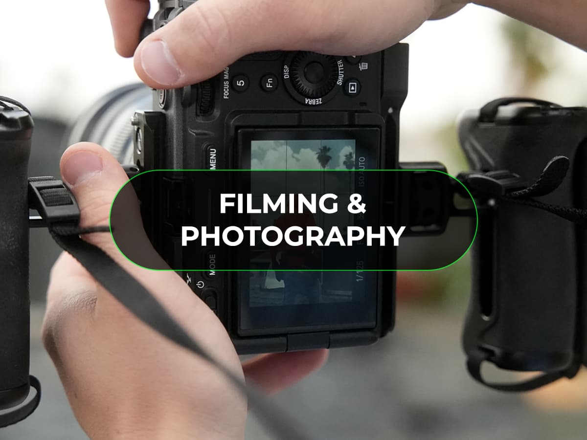 Hands operating a camera with "Filming & Photography" overlay